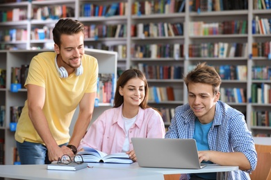 Group of young people studying at table in library