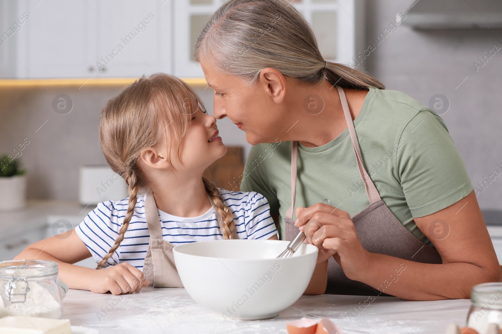 Photo of Happy grandmother with her granddaughter cooking together in kitchen