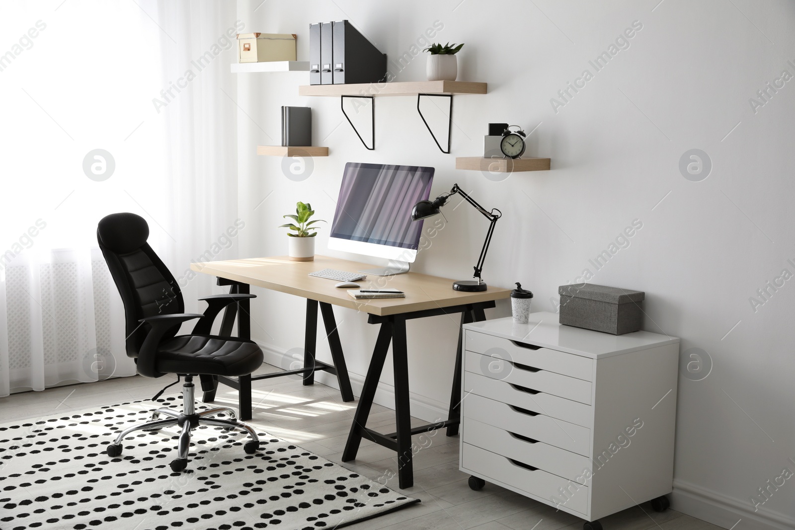 Photo of Comfortable office chair near table with modern computer