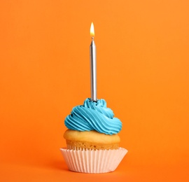 Birthday cupcake with candle on orange background