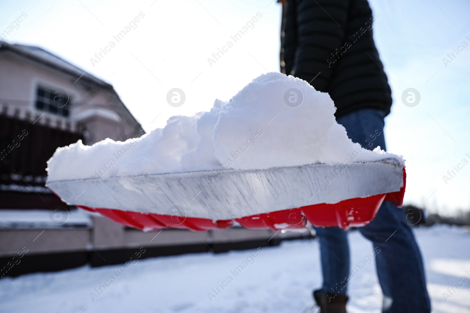 Photo of Person shoveling snow outdoors on winter day, closeup