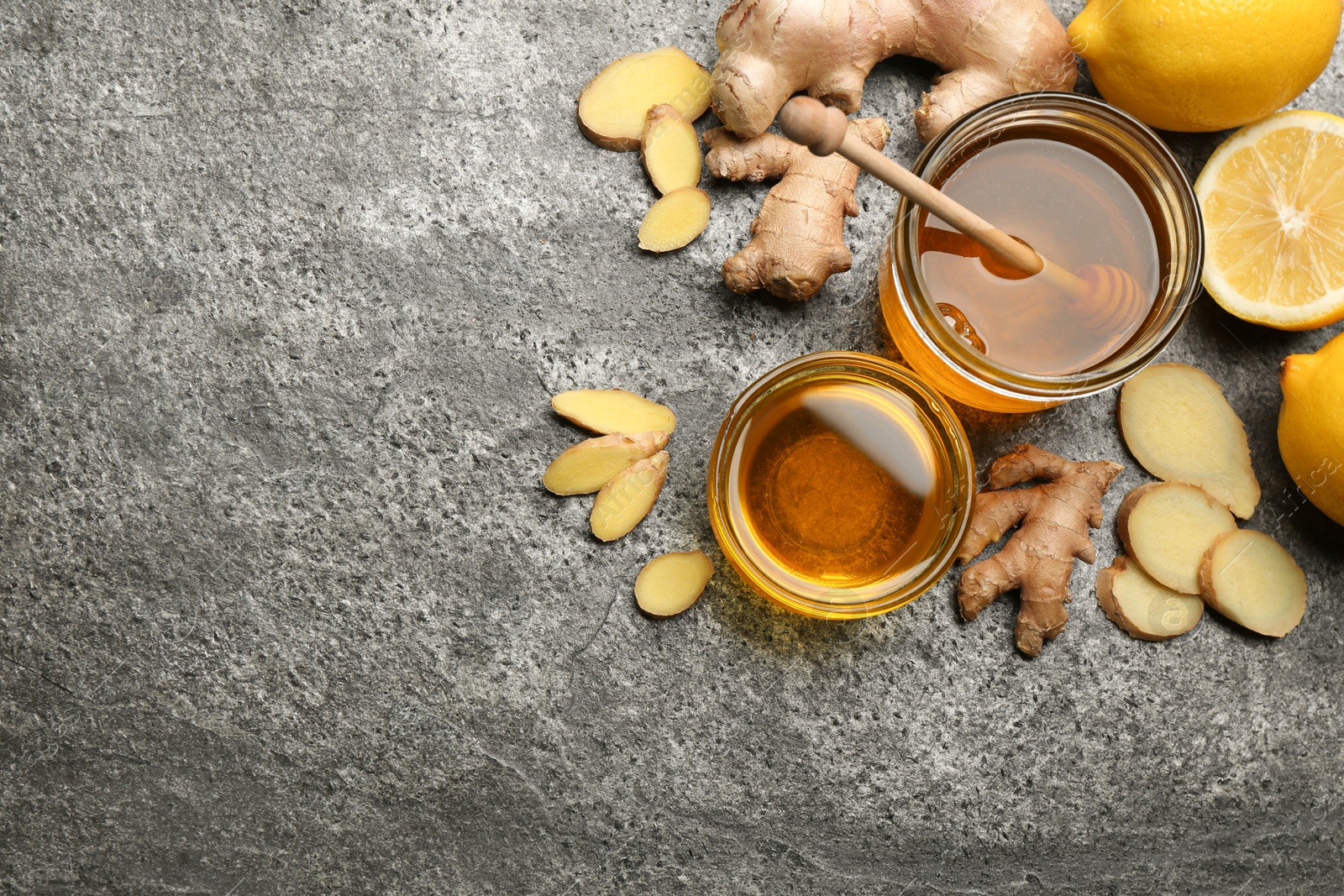 Photo of Ginger and other natural cold remedies on grey table, flat lay. Space for text