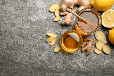 Photo of Ginger and other natural cold remedies on grey table, flat lay. Space for text