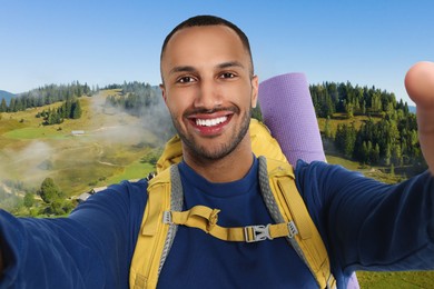 Image of Happy tourist with backpack taking selfie in mountains