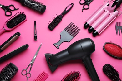 Photo of Flat lay composition of different professional hairdresser tools on pink background