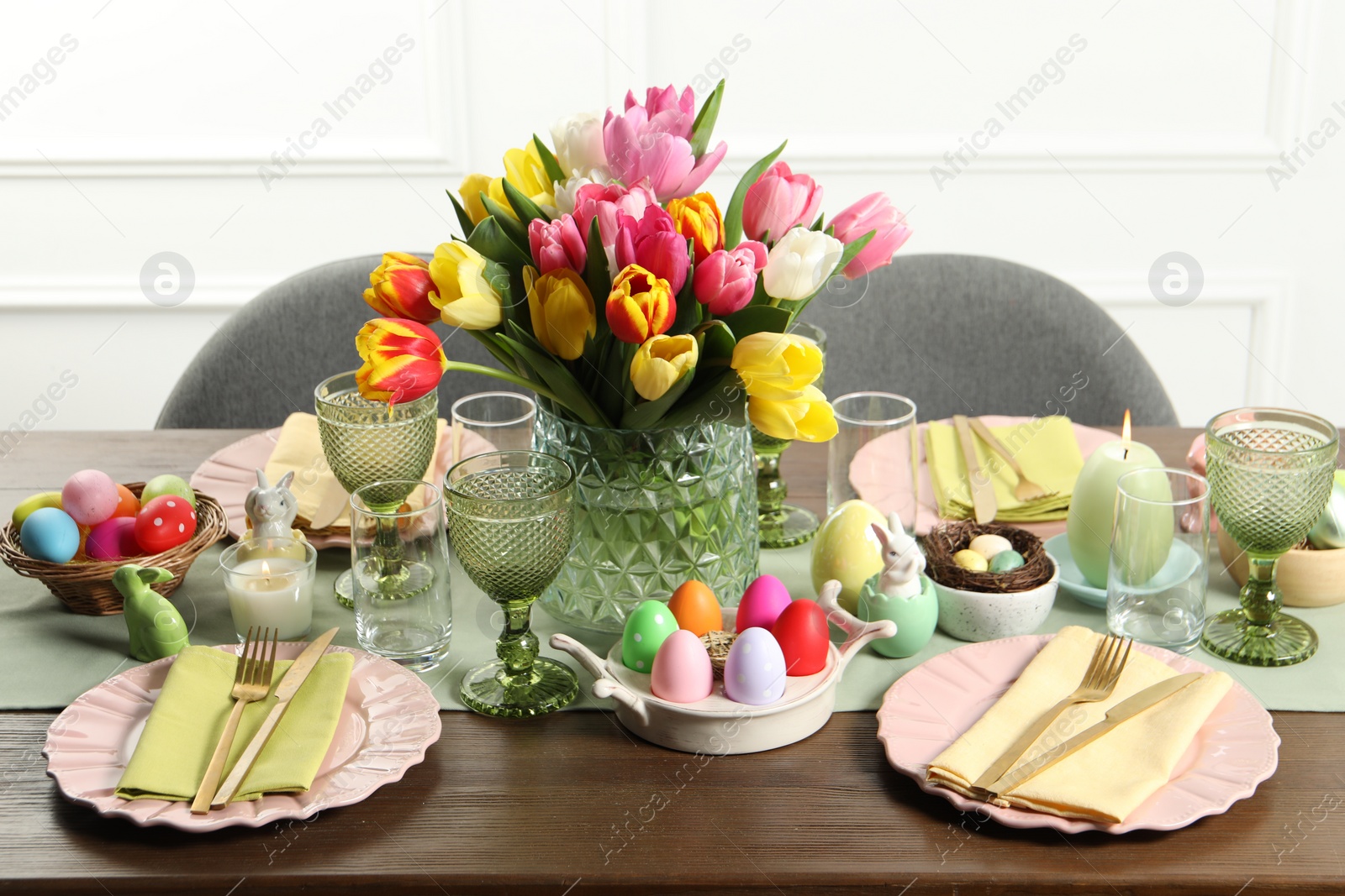 Photo of Easter celebration. Festive table setting with beautiful flowers and painted eggs