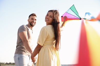 Photo of Happy couple playing with kite near sea. Spending time in nature