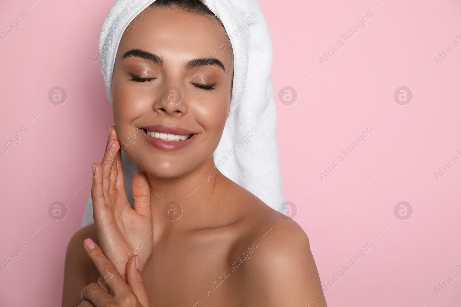 Photo of Beautiful young woman with towel on head against pink background