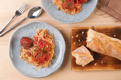 Delicious pasta with meatballs and tomato sauce on wooden background, top view