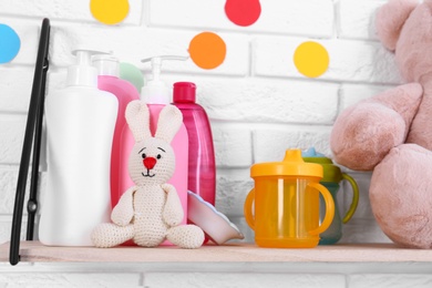 Photo of Baby accessories on shelf near white brick wall