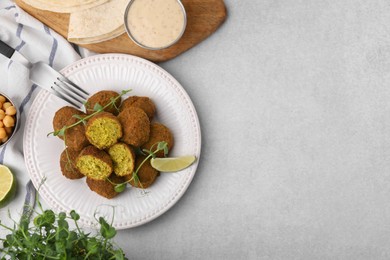 Photo of Delicious falafel balls served on light table, flat lay. Space for text