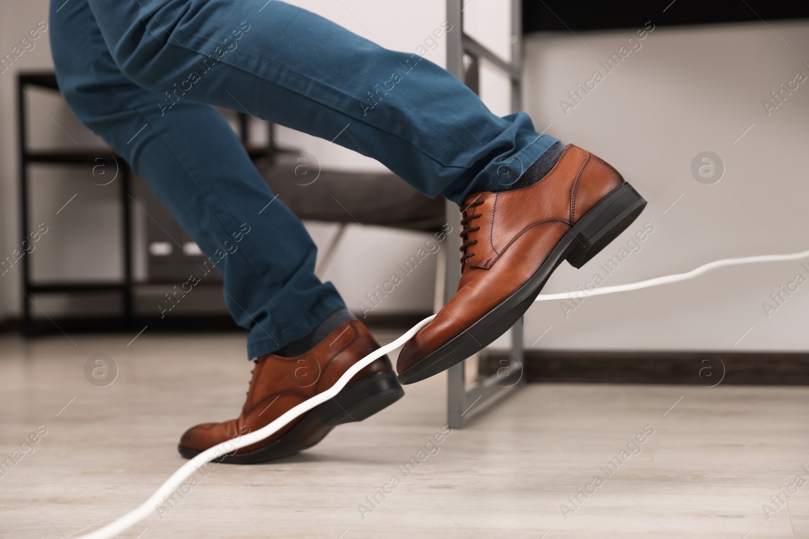 Photo of Man tripping over cord in office, closeup