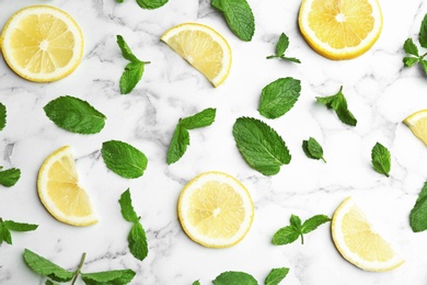 Fresh mint with sliced lemon on white marble background, flat lay