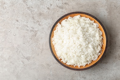 Photo of Bowl of boiled rice on grey background, top view with space for text