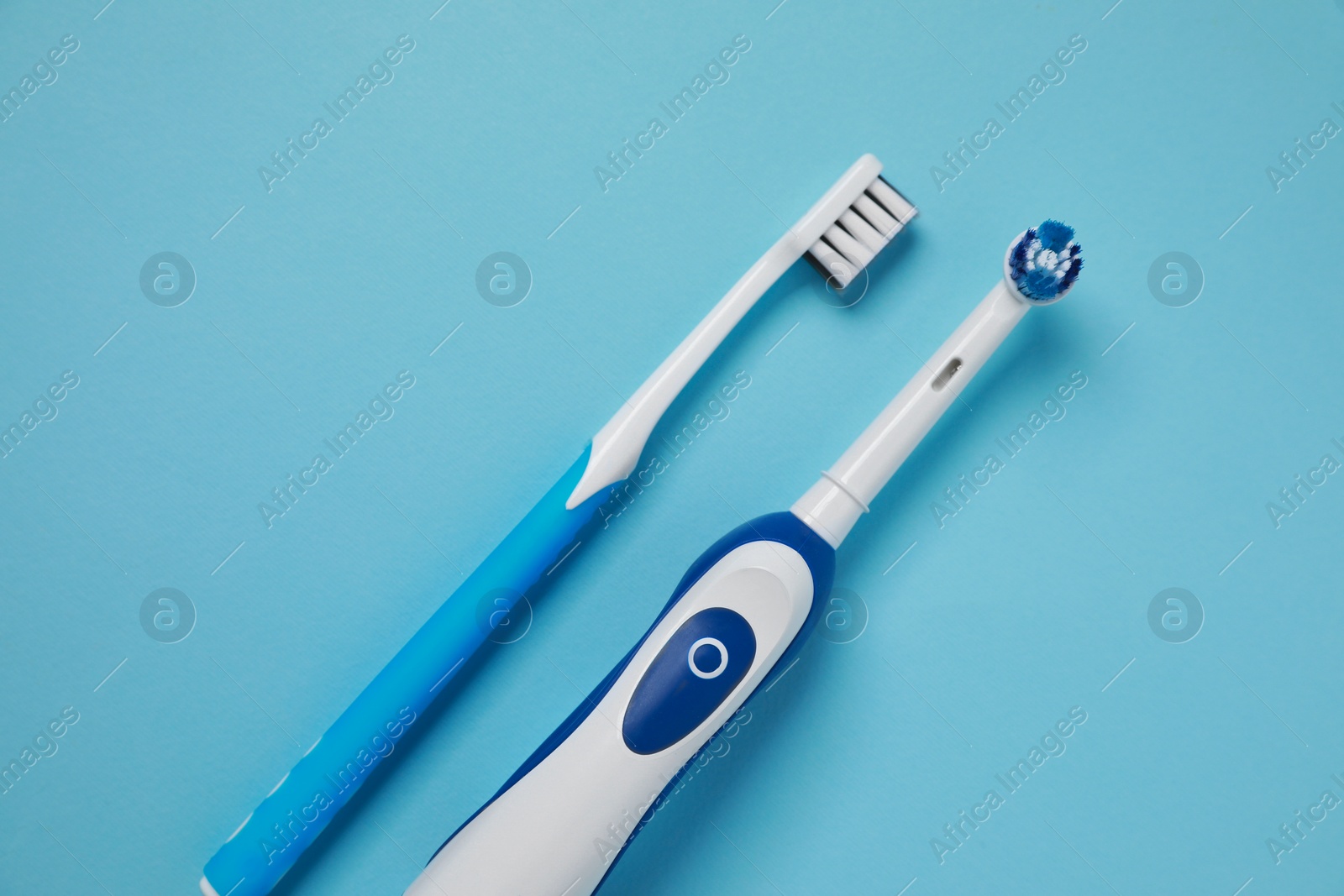 Photo of Electric and plastic toothbrushes on turquoise background, flat lay