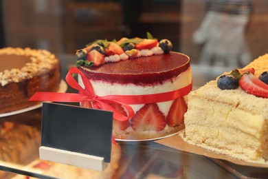 Delicious cake with strawberries on counter in bakery shop, closeup