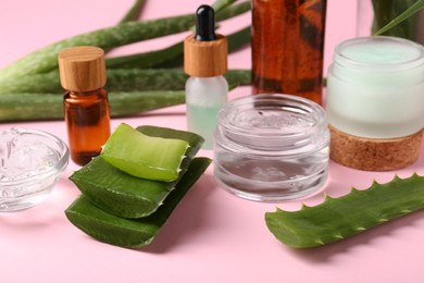 Photo of Cut aloe and natural gel on pink background, closeup