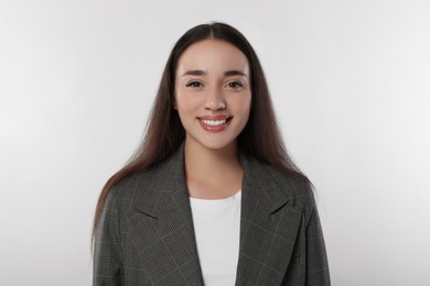 Portrait of happy young woman in stylish jacket on white background