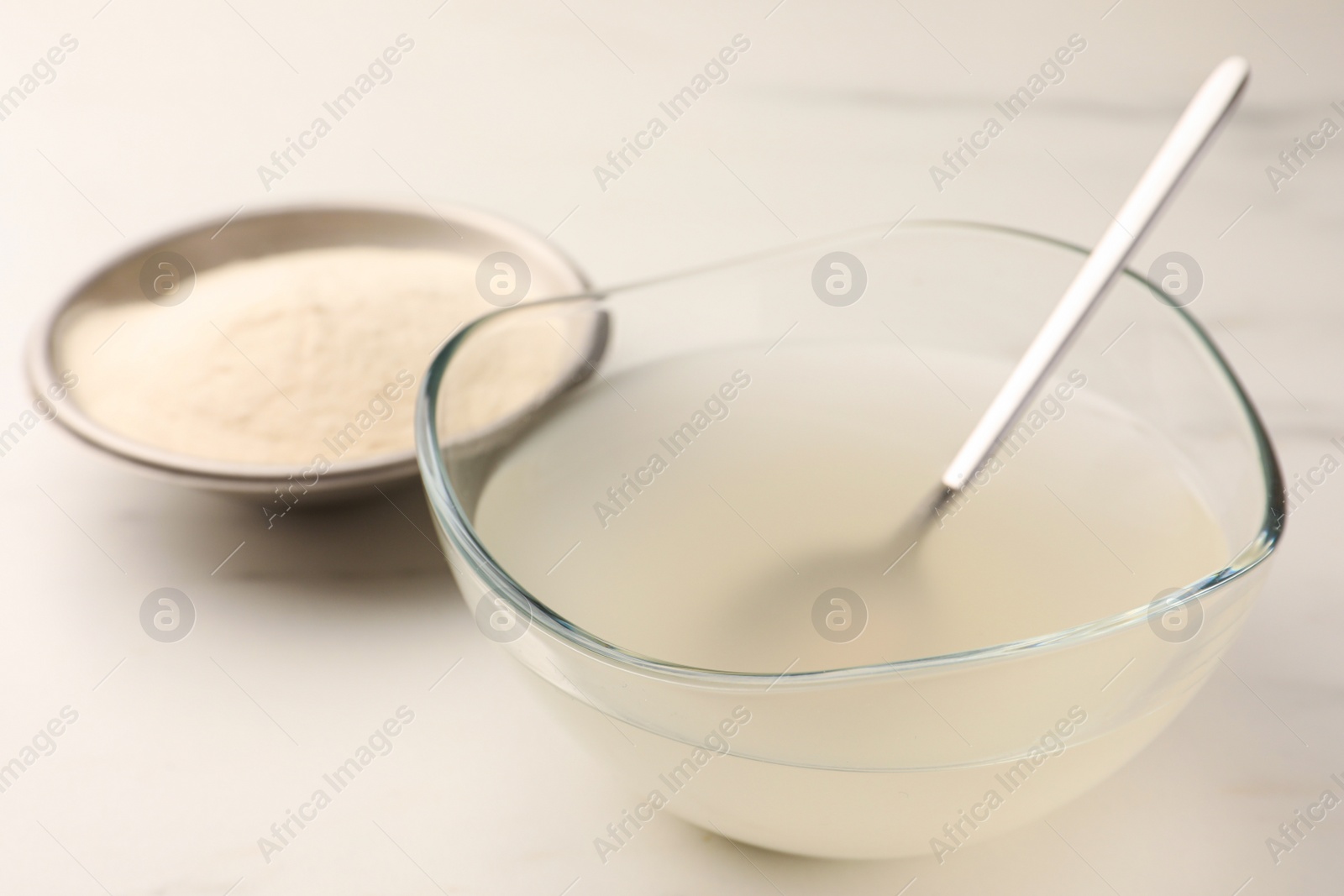 Photo of Agar-agar jelly and powder on white table, closeup