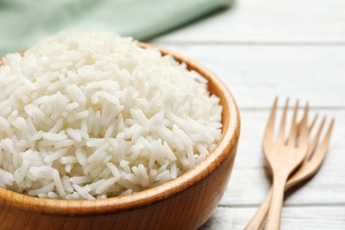 Bowl of tasty cooked rice served on table, closeup. Space for text