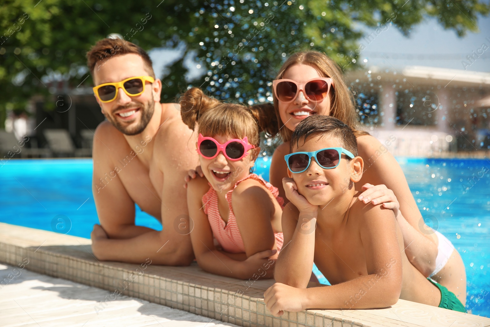 Photo of Happy family in swimming pool on sunny day