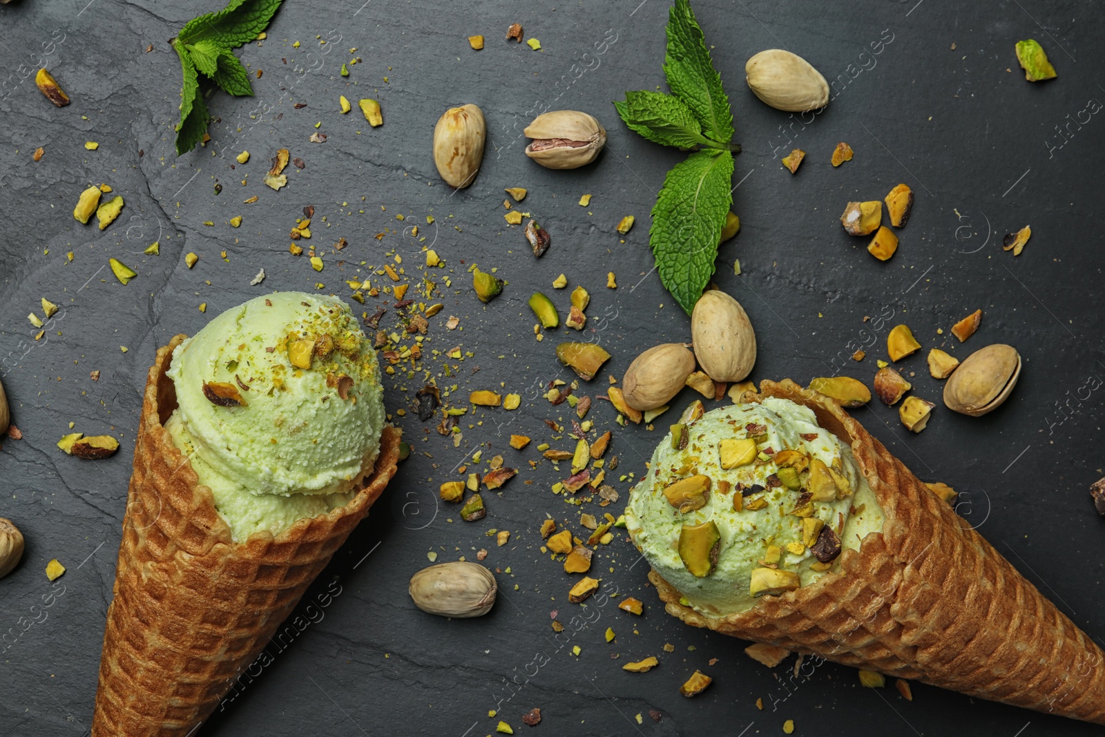 Photo of Delicious pistachio ice cream on dark table, flat lay