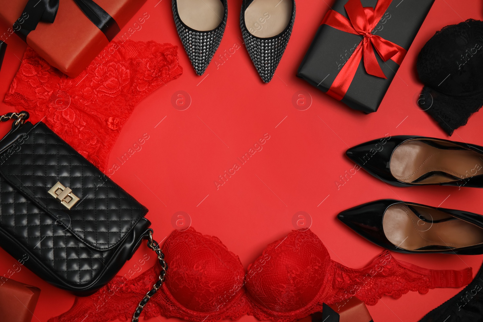 Photo of Gift boxes, women's underwear, shoes and accessories on red background, flat lay. Space for text