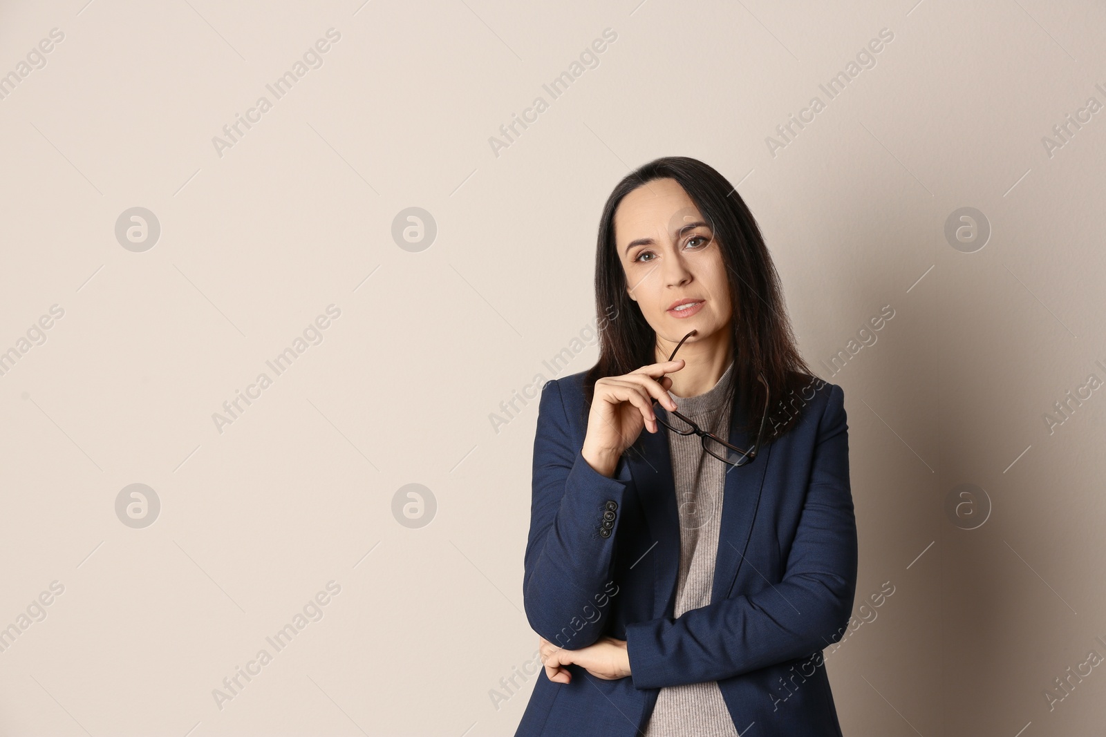 Photo of Portrait of beautiful mature woman with glasses on beige background. Space for text