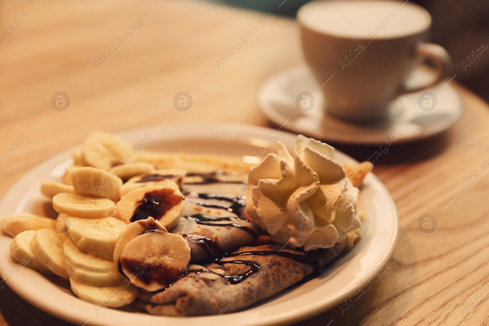 Photo of Delicious desserts and cup of aromatic coffee on wooden table, closeup