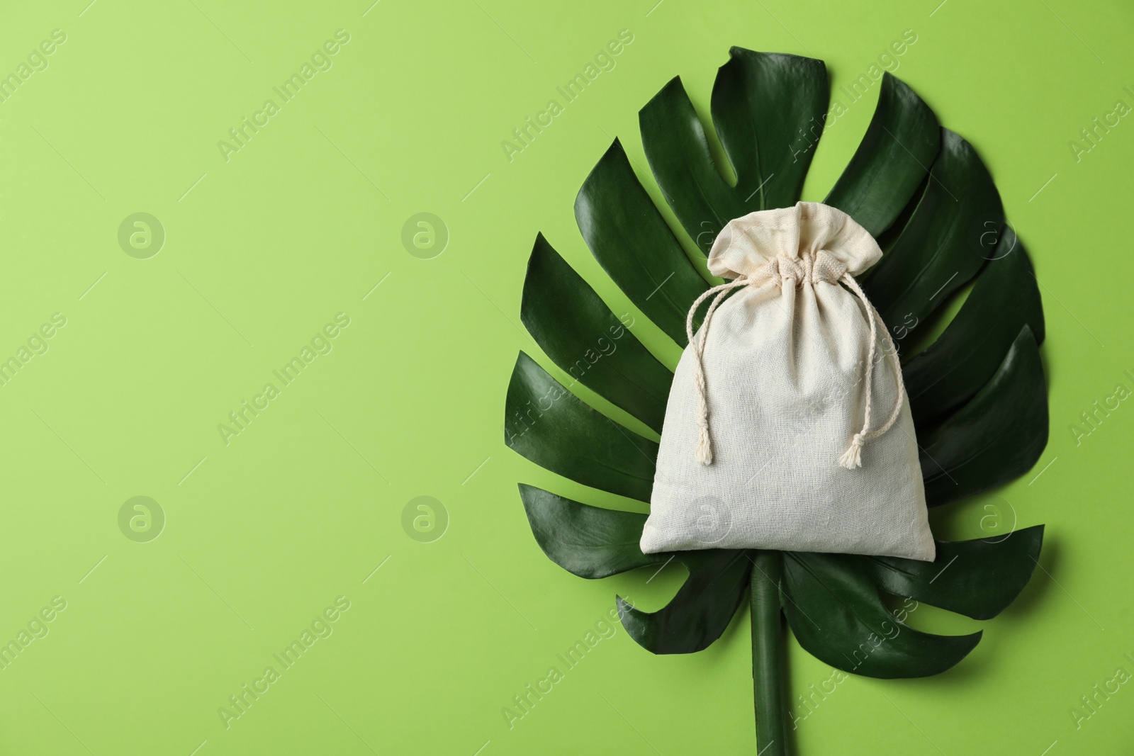 Photo of Cotton eco bag and monstera leaf, top view. Space for text