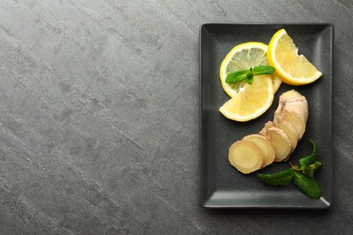 Photo of Fresh lemon, ginger and mint on grey table, top view. Space for text