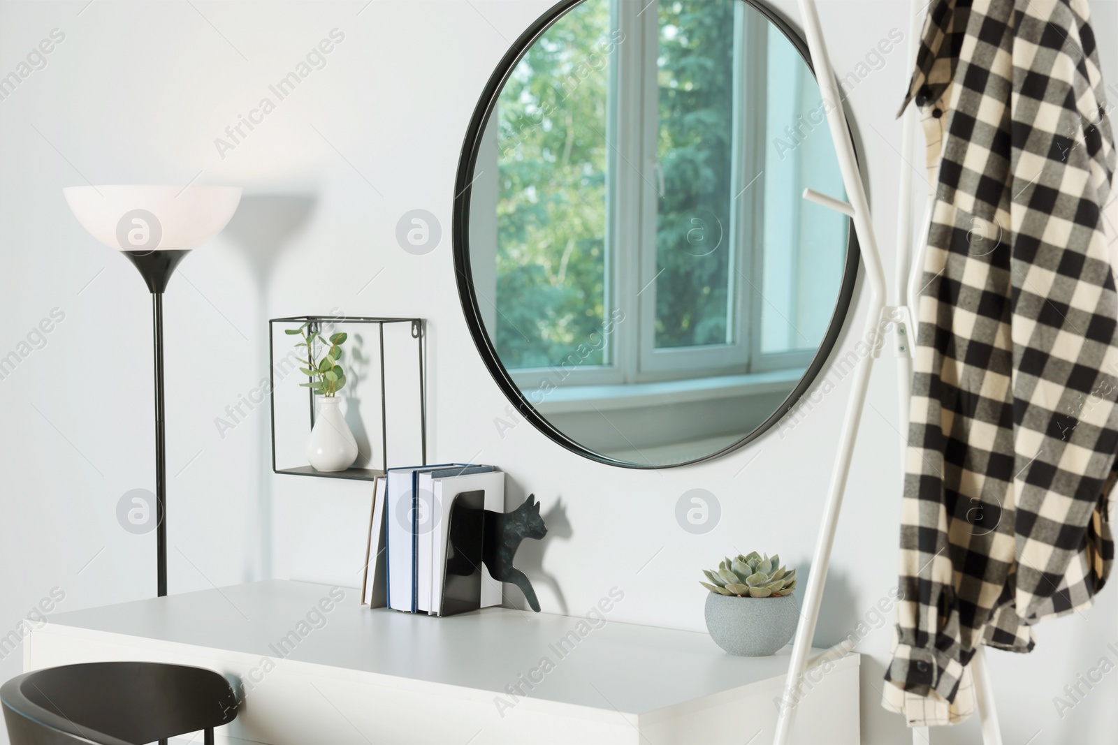 Photo of Stylish round mirror on white wall over desk in room