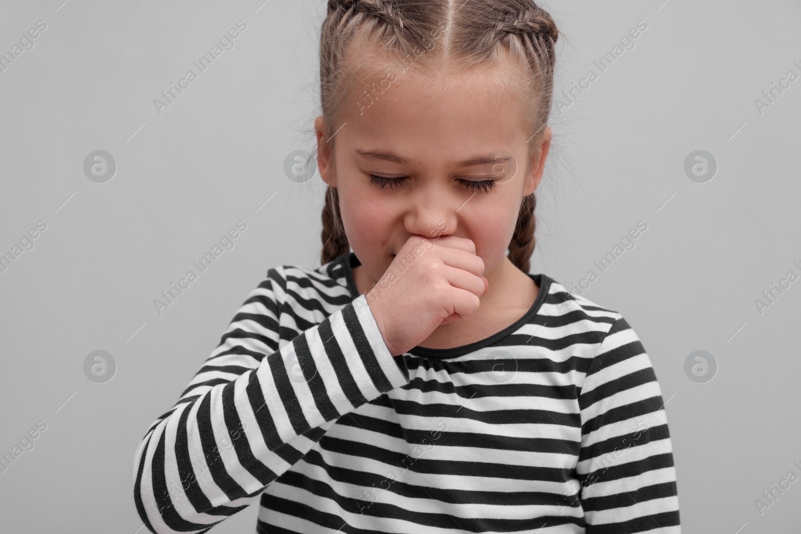 Photo of Sick girl coughing on gray background. Cold symptoms