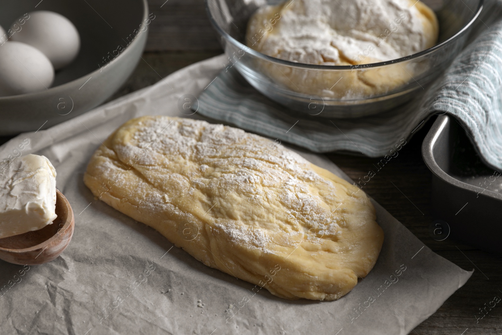 Photo of Raw dough for ciabatta and flour on wooden table