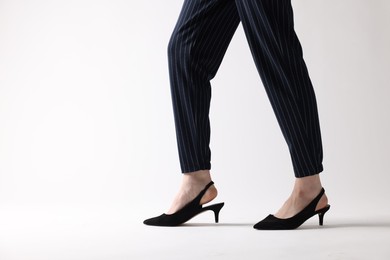 Businesswoman in black shoes on white background, closeup