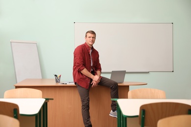 Portrait of male teacher in modern classroom