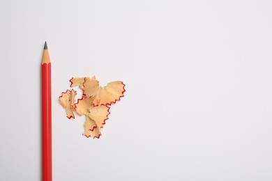Photo of Graphite pencil and shavings on white background, flat lay. Space for text