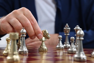 Photo of Man moving knight on chessboard, closeup view