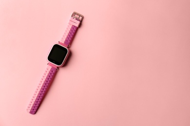 Photo of Trendy kid smart watch on pink background, top view. Space for text