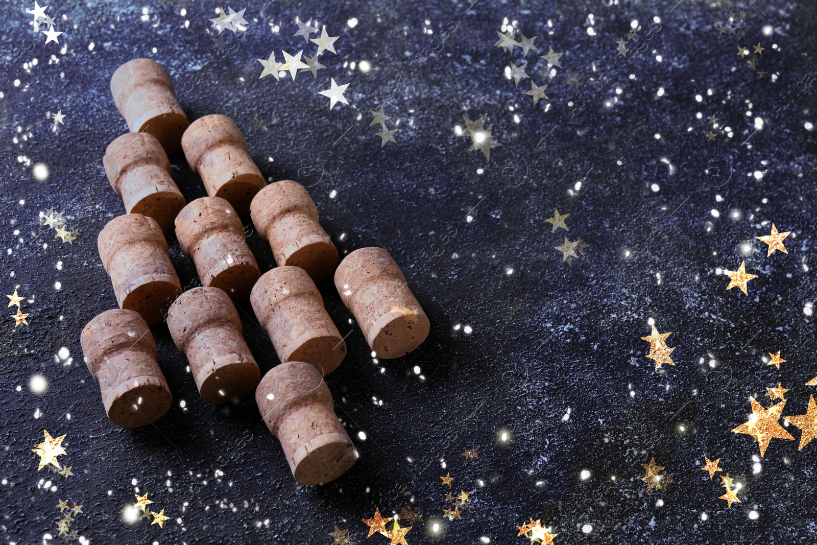 Image of Christmas tree made of sparkling wine corks on grey table. Space for text