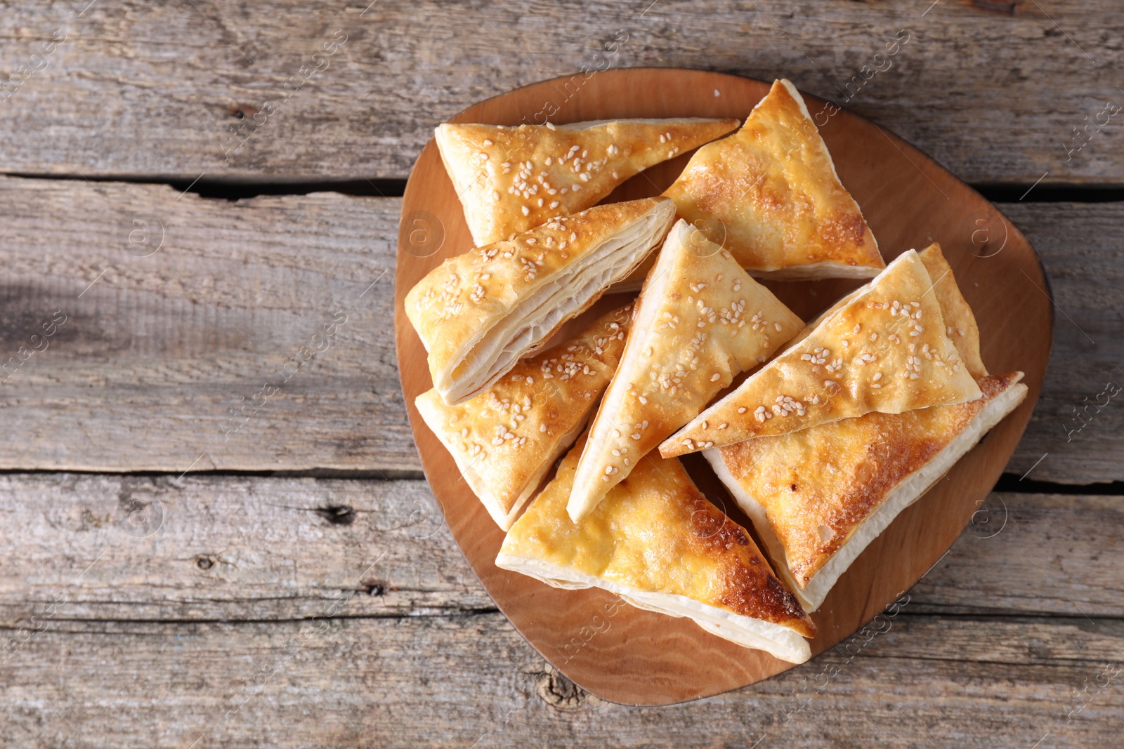 Photo of Delicious puff pastry on wooden table, top view. Space for text