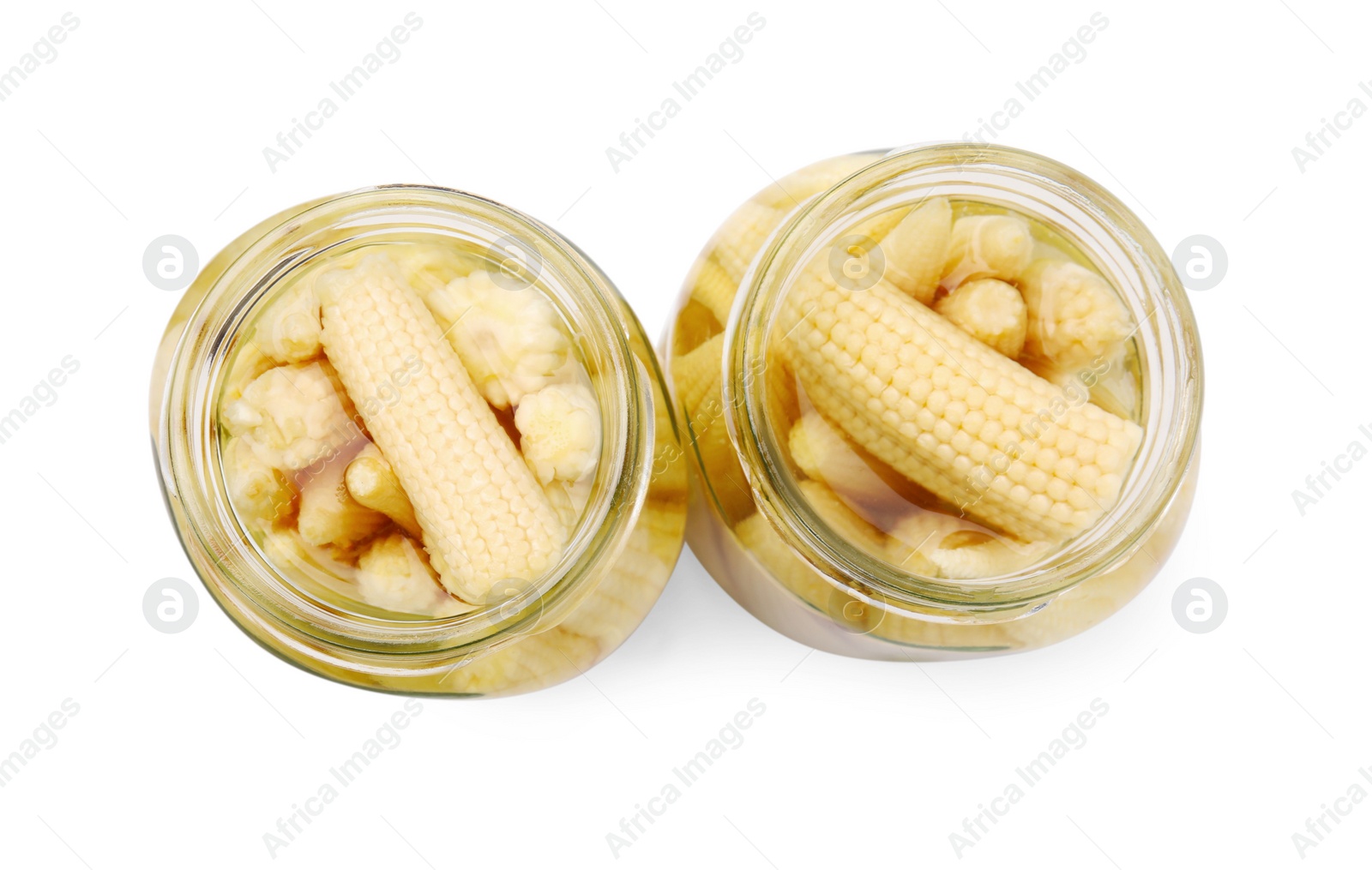 Photo of Jars of pickled baby corn isolated on white, top view