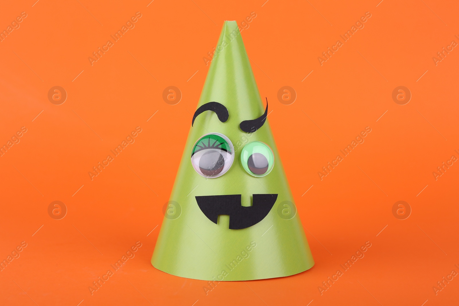 Photo of Spooky paper Halloween monster on orange background