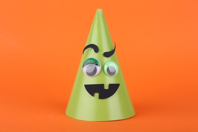 Photo of Spooky paper Halloween monster on orange background