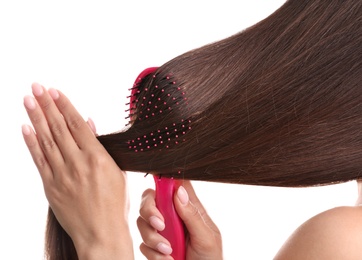 Woman with hair brush on white background, closeup