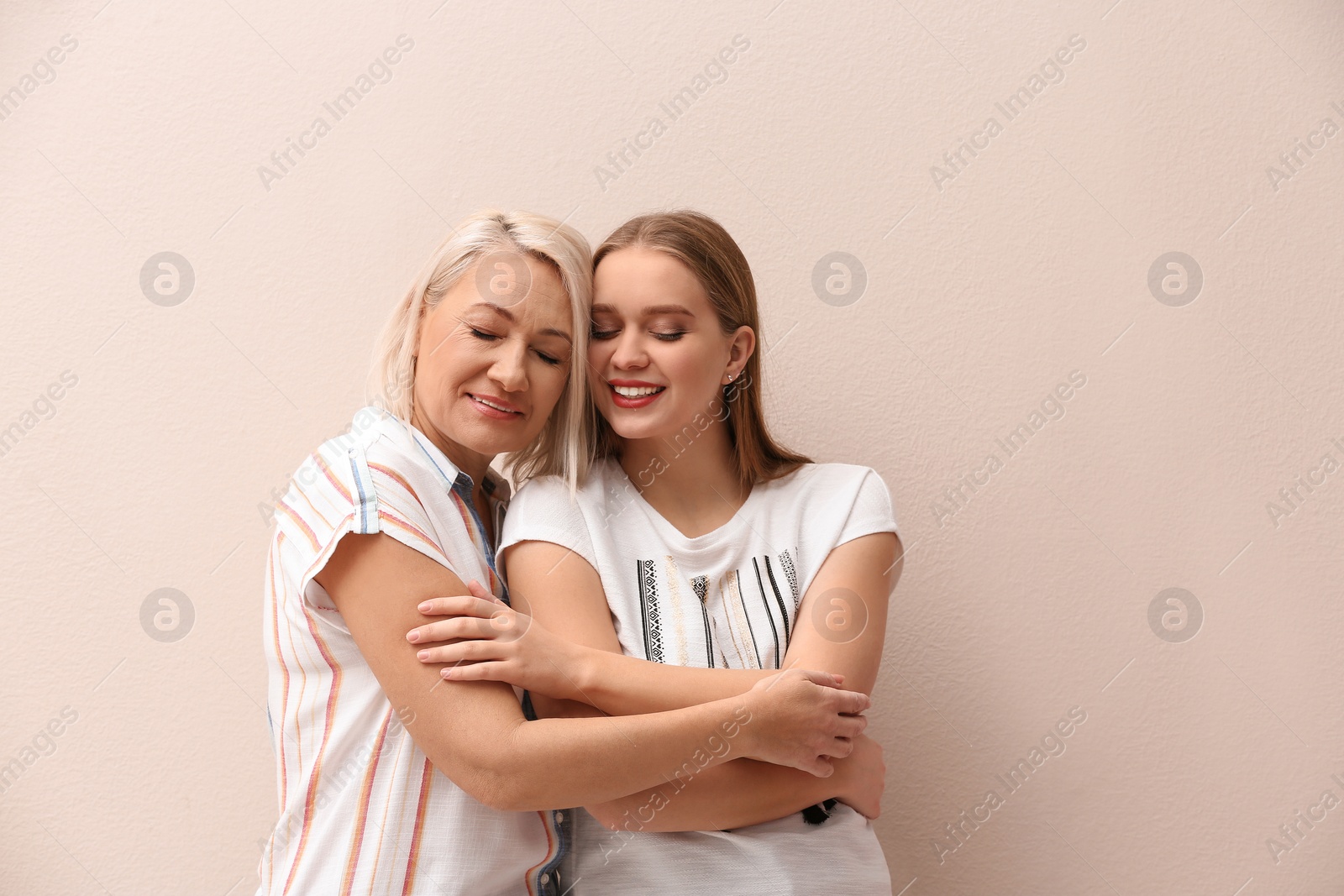 Photo of Mother and her adult daughter on beige background