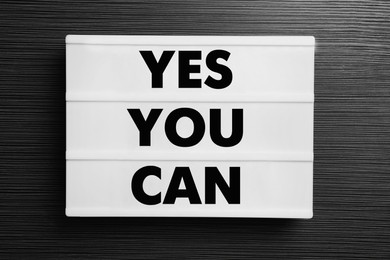 Image of Lightbox with phrase Yes You Can on black wooden table, top view