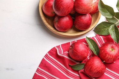 Photo of Fresh red apples with leaves on white table, flat lay. Space for text