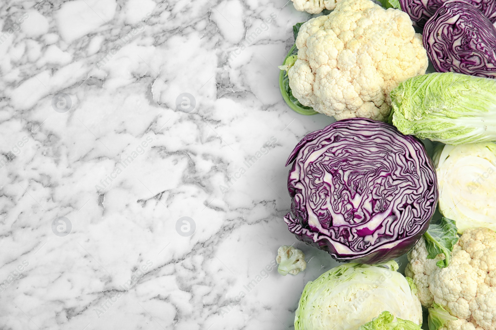 Photo of Flat lay composition with different cabbages on marble background