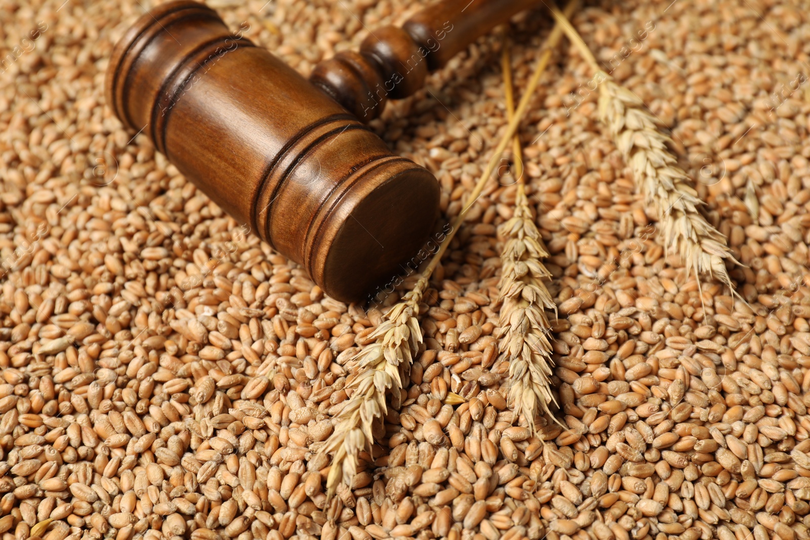 Photo of Wooden gavel and wheat ears on grains, closeup. Agricultural deal